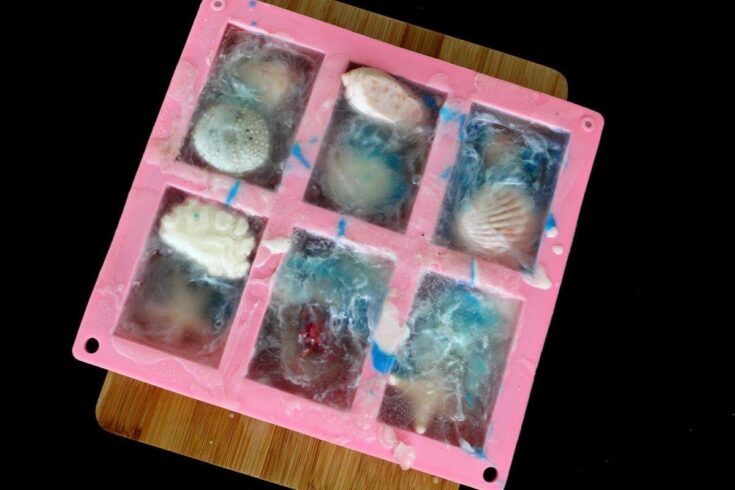 Melt and pour seashell soap DIY for summer. An easy melt and pour soap recipe for summer fun. Adult crafts to make this summer or DIY crafts to make and sell on Etsy, online and at craft fairs and farmers markets. A summer soap soap making project for DIY seashell soap for family summer fun. Easy crafts to make while bored at home. A wonderful soap crafting project using melt and pour glycerin soap base reminiscent of summertime beach trips. How to make melt and pour soap for using soap embeds.