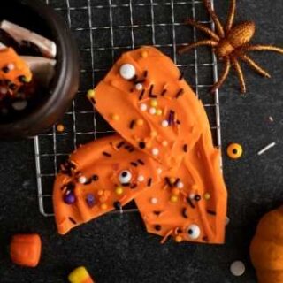 Make this fun Halloween bark recipe for your Halloween party as treats for your tricksters. An easy recipe for Halloween chocolate bark with candy pieces and sprinkles.
