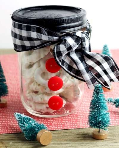 How to make white chocolate covered pretzels to give as homemade Christmas food gifts this holiday season. These easy pretzels covered in white chocolate make wonderful mason jar food gifts. Make my 2-ingredient white chocolate covered pretzels recipe. Plus find instructions on making a snowman mason jar to share your holiday treats. Free printable gift tags are included to tie your DIY holiday gift together! This mason jar food gift also works for chocolate bark, chai tea mix or bourbon balls.