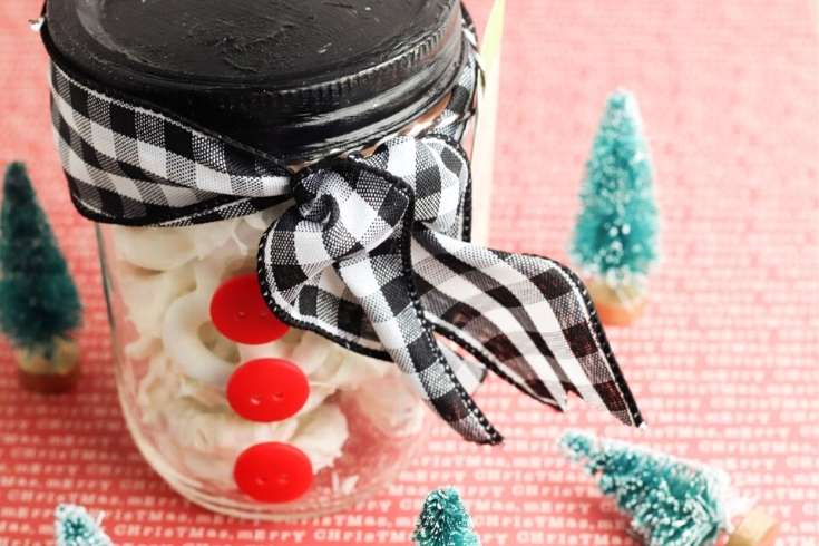 How to make white chocolate covered pretzels to give as homemade Christmas food gifts this holiday season. These easy pretzels covered in white chocolate make wonderful mason jar food gifts. Make my 2-ingredient white chocolate covered pretzels recipe. Plus find instructions on making a snowman mason jar to share your holiday treats. Free printable gift tags are included to tie your DIY holiday gift together! This mason jar food gift also works for chocolate bark, chai tea mix or bourbon balls.
