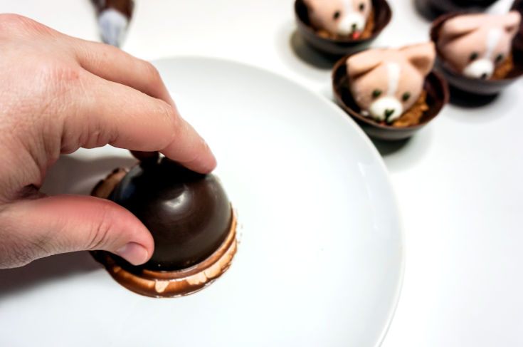 warm half of hot chocolate bomb on warm plate to melt slightly to connect two sides of hot cocoa bombs together