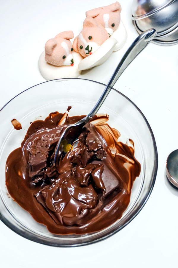 mixing melted chocolate to make hot chocolate bombs with marshmallows corgi