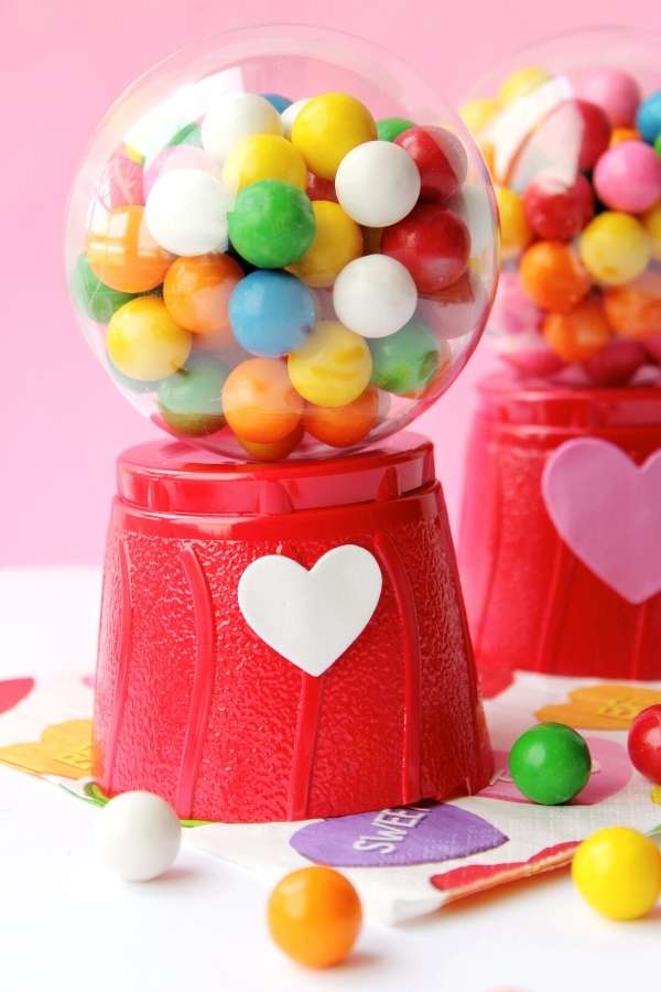 DIY Valentines for Kids: How to Make Mini Gumball Machines with free printable valentines for kids. Plus more Valentine's day crafts for the perfect DIY Valentine's day gifts for kids. This DIY mini gumball machine is the perfect Valentine for your little mini me's! Kids absolutely love these replica gumball machines filled with multi-colored gumballs or Valentine's day candy. Plus they're simple and easy to make. Keep reading to learn how to make this easy Valentine's day craft for kids.